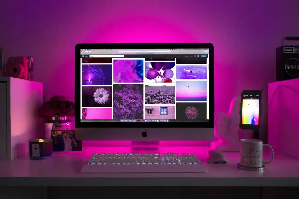 About 7 A desktop computer displaying various images with a pink lighting effect in the background.